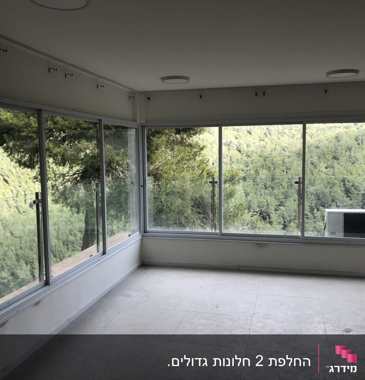 חלונות אלומיניום גדולים עם נוף ליער ירוק